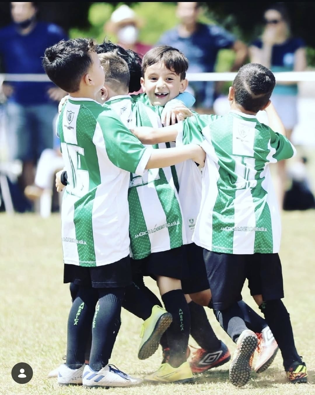Alunos do sub 7 da América Mineiro se abraçando para comemorar em campo