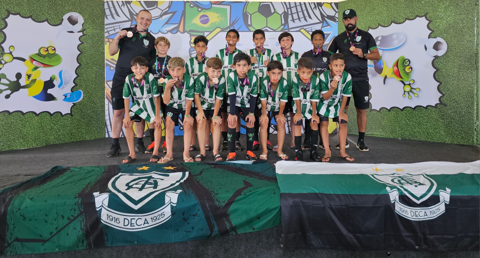 Turma do sub 11 da América Mineiro posada no palco com medalhas de campeonato